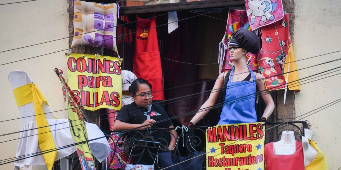 Una mujer observa desde el balcón de una tienda de mandiles, en marzo.