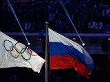 la bandera de Rusia ondea al lado de la bandera olímpica durante la ceremonia de clausura de los Juegos Olímpicos de Invierno 2014 en Sochi.