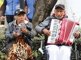 La pareja de adultos canta en un parque de la CDMX para ganar dinero, ayer.