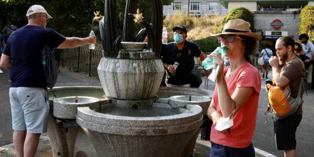 La gente recoge agua de una fuente en Green Park en Londres.
