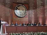 El ministro Pérez Dayán (podio) en el Teatro de la República en Querétaro, ayer frente a representantes de los otros Poderes, el gobernador Kuri y miembros del gabinete federal.