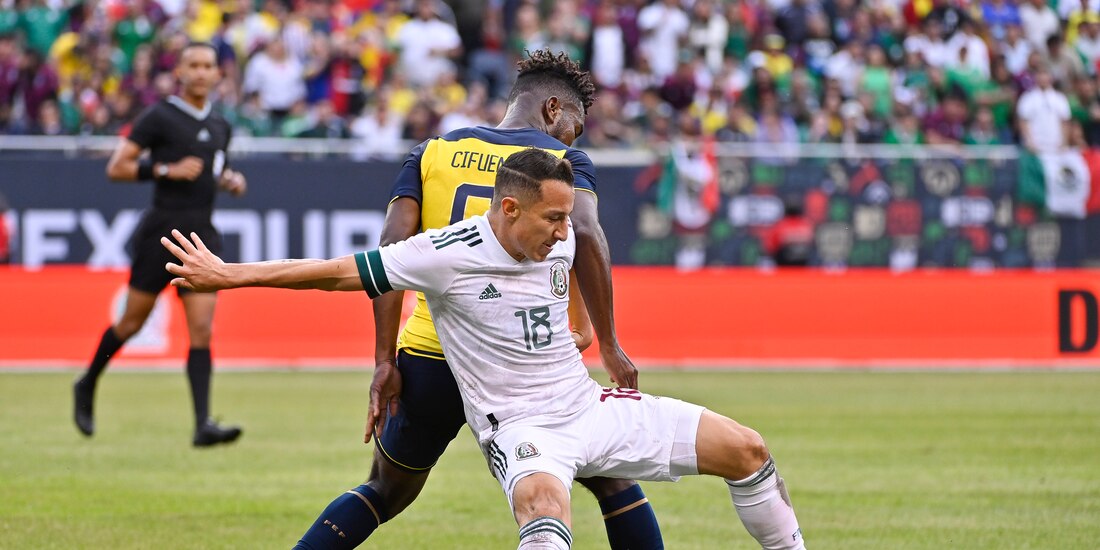 Andrés Guardado intenta quitarse la marca de José Cifuentes en el partido amistoso entre México y Ecuador.