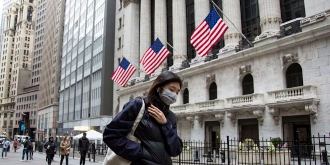 Una mujer camina con cubrebocas.