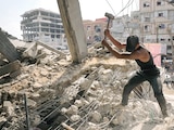 Palestinos extraen hierro de escombros para construir tiendas de campaña, ayer.