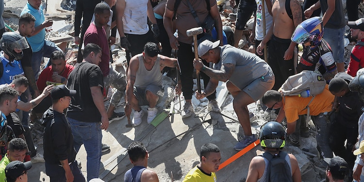 Residentes buscan sobrevivientes entre los escombros después de que un terremoto sacudió Cali, Colombia, el lunes