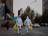 FOTO DE ARCHIVO. Trabajadores de prevención con trajes protectores cruzan una calle mientras continúan los brotes de la enfermedad por coronavirus (COVID-19) en Pekín, China. 9 de diciembre de 2022. REUTERS/Thomas Peter