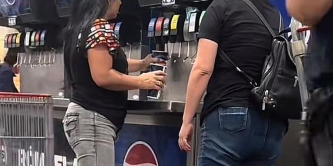 mujeres se llevan el refresco de una máquina del Costco.
