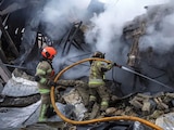 Bomberos apagan el fuego en un centro comercial atacado con misiles rusos, ayer.
