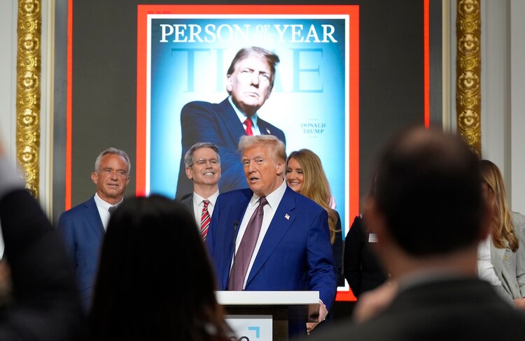 El magnate Donald Trump posa frente a su segunda portada como figura del año de la revista TIME, ayer.