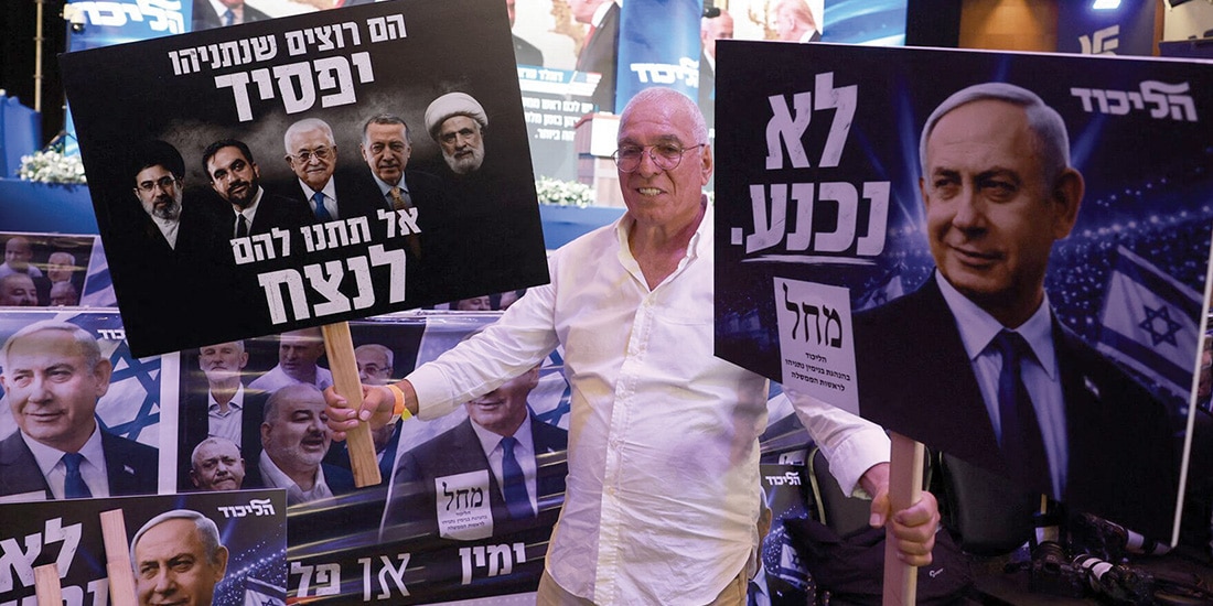 Un partidario sostiene carteles del partido Likud, ayer.