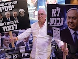 Un partidario sostiene carteles del partido Likud, ayer.