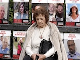 Una mujer espera frente a un cartel de retenidos por Hamas, ayer, en Tel Aviv, Israel.