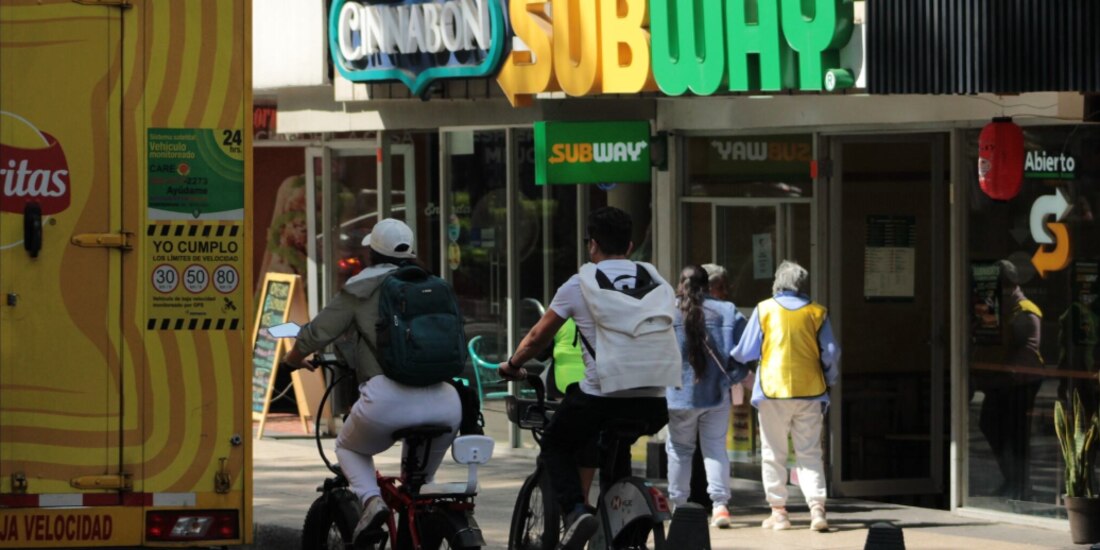 Una joven conduce una bicicleta eléctrica en la ciclovía de Reforma.