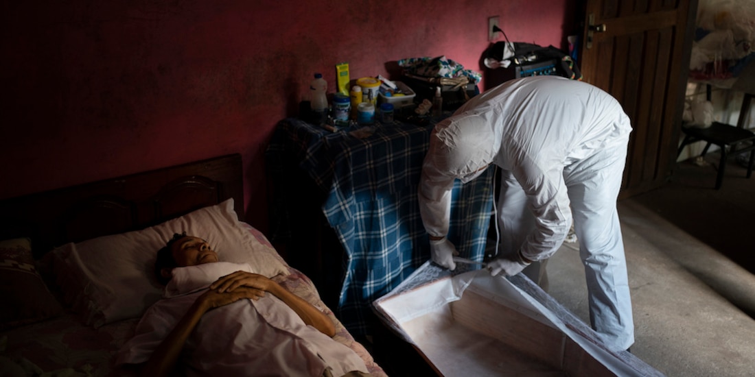 Un sepulturero recoge el cuerpo de una mujer que murió por Covid-19, ayer, en un suburbio de Sao Paulo, Brasil.
