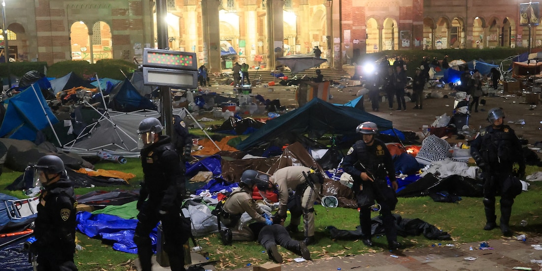 Uniformados someten a un joven tras arrasar con el campamento en la UCLA, ayer.