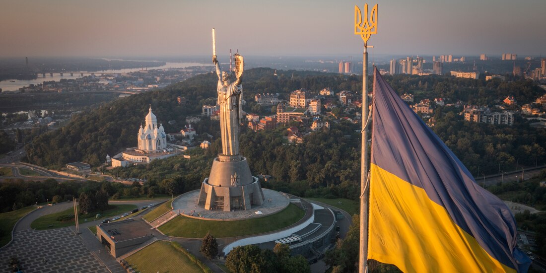 La bandera ucraniana ondea mientras trabajadores instalan el escudo del país en la estatua más alta del país, la estatua de la Madre Ucrania, luego de que retiraron el martillo y la hoz soviéticos, el domingo 6 de agosto de 2023, en Kiev
