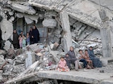 Mujeres y niños palestinos, entre escombros en la Ciudad de Gaza, ayer.