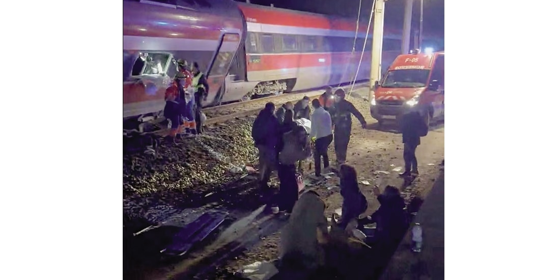 Personas son rescatadas de uno de los trenes accidentados, ayer.