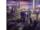 Personas son rescatadas de uno de los trenes accidentados, ayer.