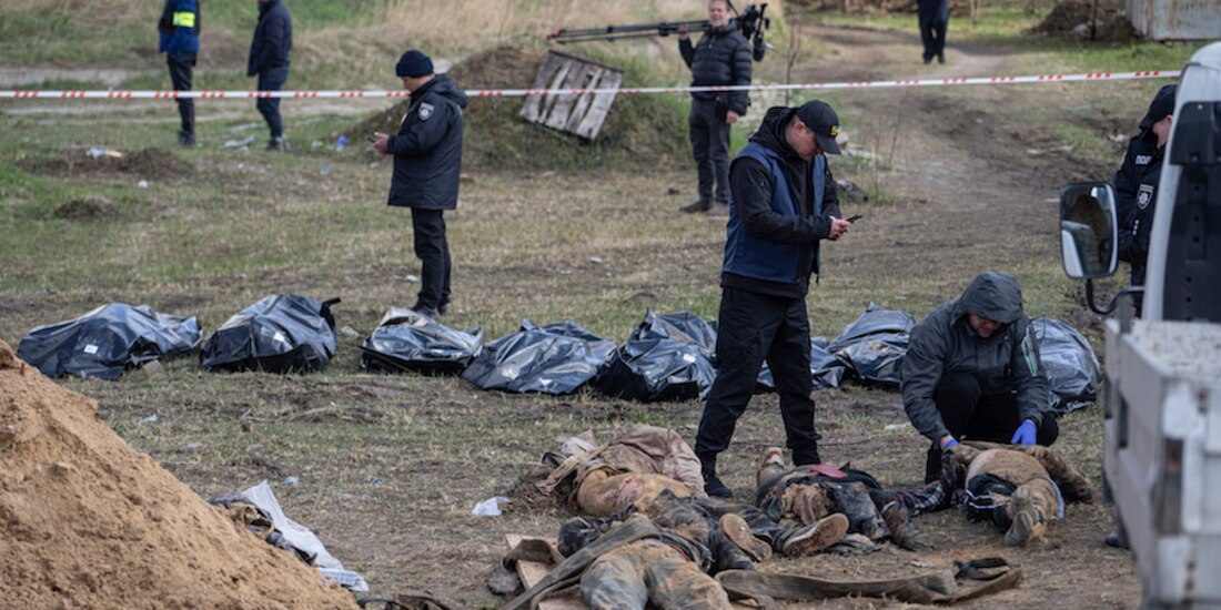 Médicos forenses rastrean cuerpos al interior de fosas en zonas cercanas a Kiev, ayer.