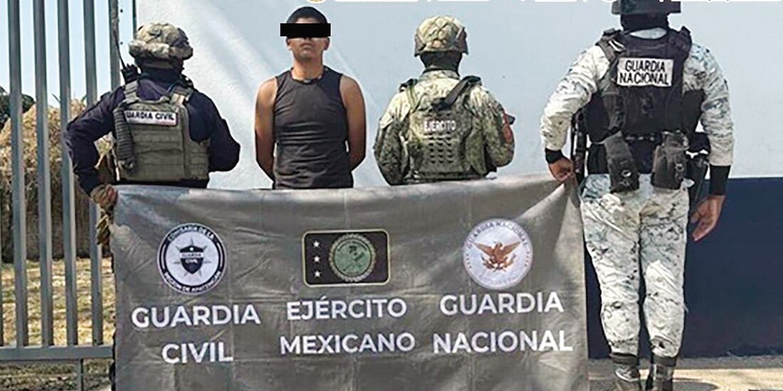 Elementos de seguridad custodian a uno de los detenidos en el marco del Plan Michoacán.