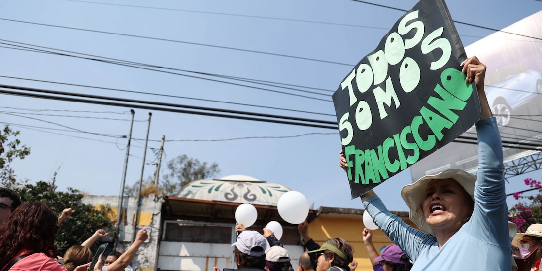 Una mujer celebra afuera de las instalaciones del Refugio Franciscano.