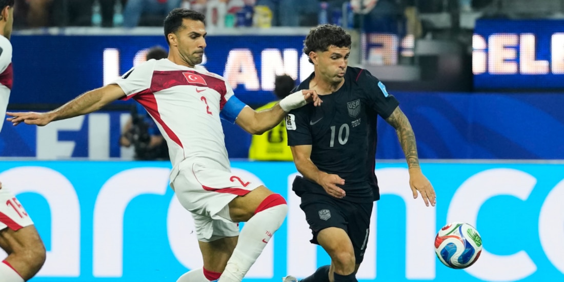 Christian Pulisic y Zeki Celik peleando un balón en el partido.