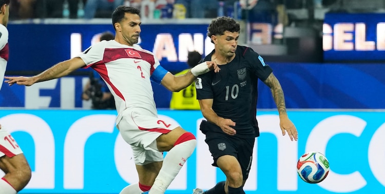 Christian Pulisic y Zeki Celik peleando un balón en el partido.