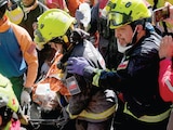 LOS RESCATISTAS transportan a Hernán Alberto Gil Flores tras ser rescatado ocho días después de los dos terremotos en Venezuela, ayer