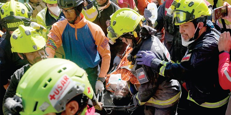 LOS RESCATISTAS transportan a Hernán Alberto Gil Flores tras ser rescatado ocho días después de los dos terremotos en Venezuela, ayer