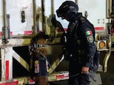 Un agente y su binomio canino inspeccionan la caja del tractocamión, ayer.