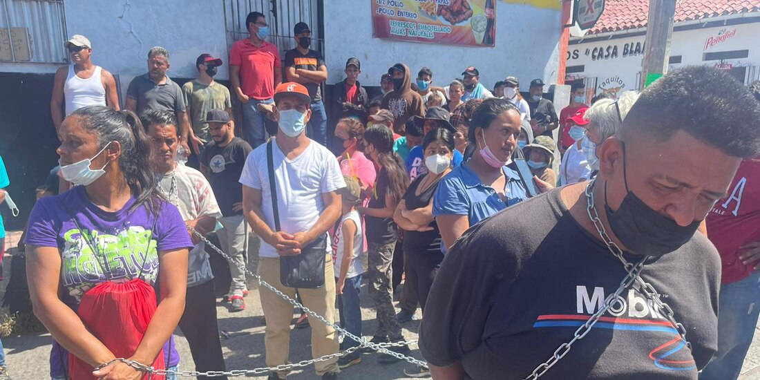 Los migrantes protestaron con cadenas amarradas en el cuello.
