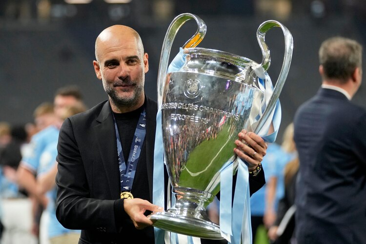 Pep Guardiola festeja con el trofeo de la Champions League después del triunfo del Manchester City sobre el Inter de Milán.