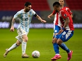 Lionel Messi conduce el esférico ante la marca de un guaraní en el Argentina vs Paraguay de la Copa América 2021.