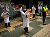 Una trabajadora de la salud alza un cartel por la huelga general para exigir mayor protección en su trabajo, Pamplona, España.