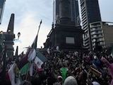 Aficionados desafían la lluvia y festejan victoria de México en el Ángel de la Independencia