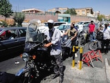 Motocicletas y automóviles hacen fila frente a una gasolinera en Teherán, ayer.