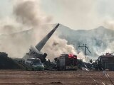 Los bomberos acuden al sitio en el que un avión que se salió de la pista en el Aeropuerto Internacional de Muan en Muan, provincia de Jeolla del Sur, Corea del Sur.