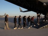 En imagen de archivo, migrantes deportados abordan un avión militar de Estados Unidos
