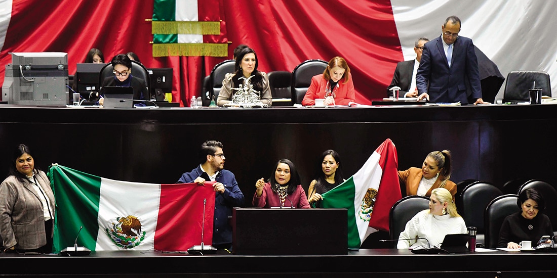 Legisladores de Morena muestran banderas de México durante la sesión en la Comisión Permanente, ayer.