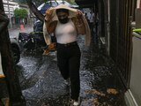 Una capitalina se cubre con su suéter mientras corre de la fuerte lluvia registrada en la alcaldía Coyoacán, en la CDMX.