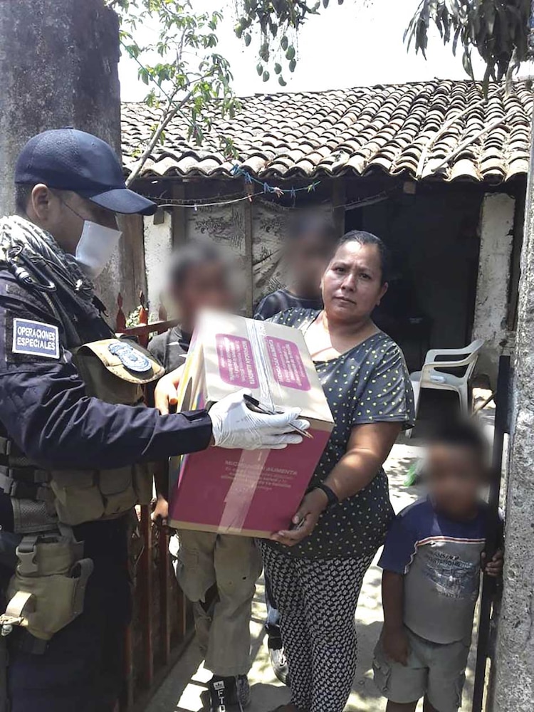 Una beneficiaria recibe la ayuda de manos de un oficial estatal.