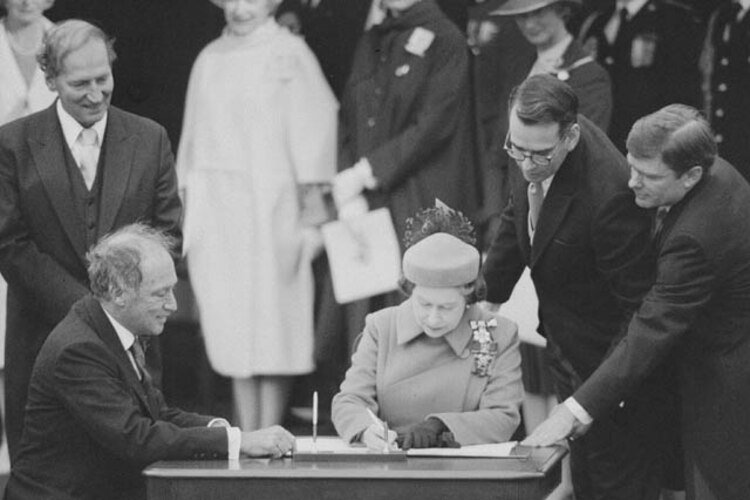 La reina Isabel II firma la Constitución de Canadá.