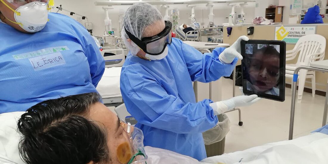 Fotografía de un médico de Quintana Roo que asiste a un paciente covid para comunicarse con familiares.