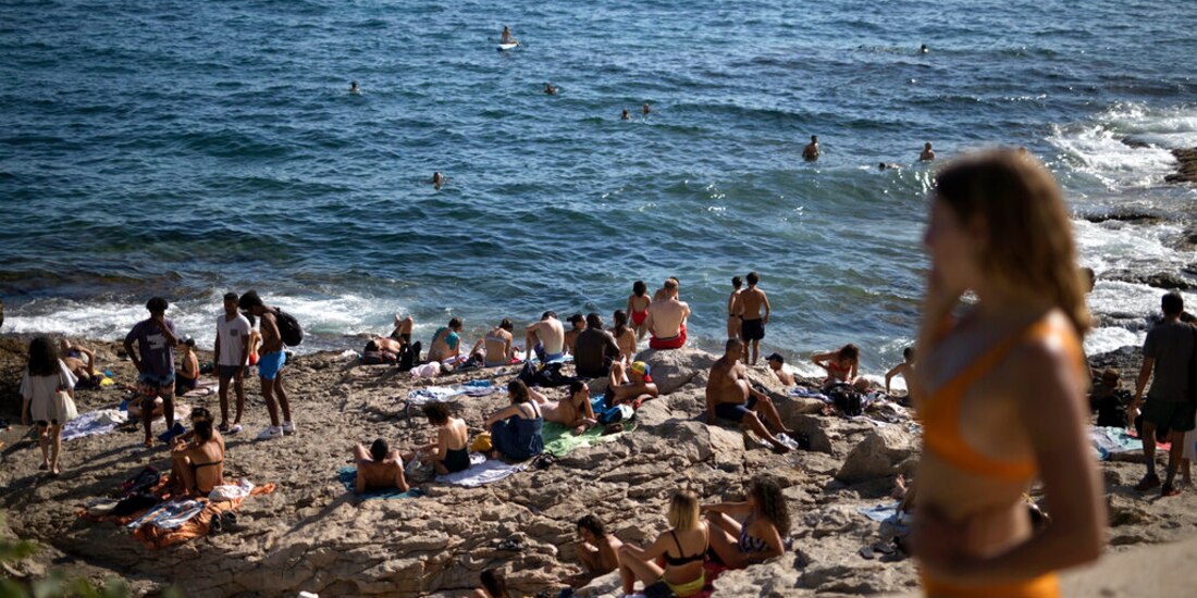 Gente disfruta del sol y la playa Malmousque en Marsella, al sur de Francia