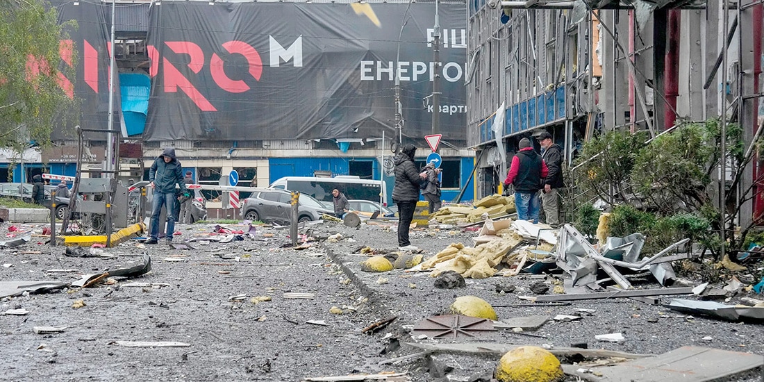 PERSONAS observan los daños en un centro de oficinas tras un ataque ruso en Kiev, ayer.