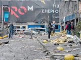 PERSONAS observan los daños en un centro de oficinas tras un ataque ruso en Kiev, ayer.