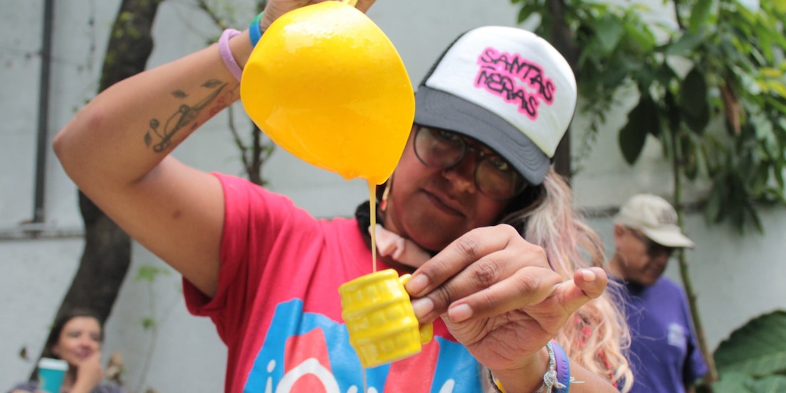 Una joven sirve un un curado de mango en una “probadita” en forma de tarro, ayer.