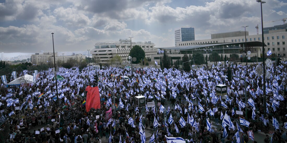 Detractores ondean banderas de Israel en protesta contra el premier de Israel.