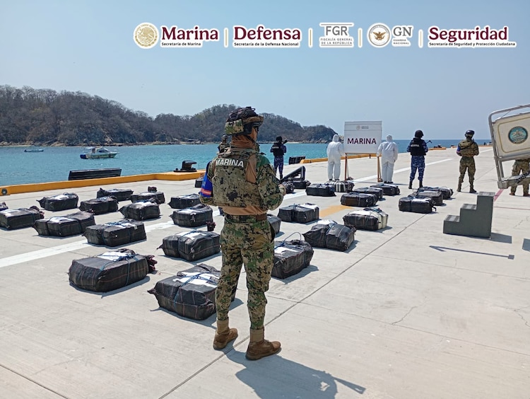 Un elemento de la Marina; al fondo, bultos de presunta cocaína.